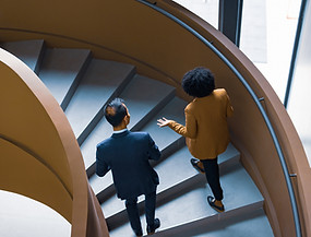 Two individuals walking up the stairs talking