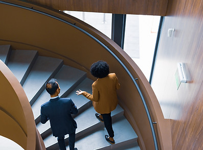Two people walking up the stairs talking