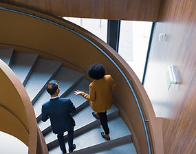 Two individuals walking up the stairs talking