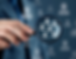 Hand holding magnifying glass focusing on white user icons. Blue blurred background with similar icons creates a professional, analytical mood.